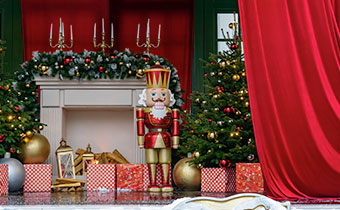 Nutcracker in front of fireplace decorated with gifts, garland and candles